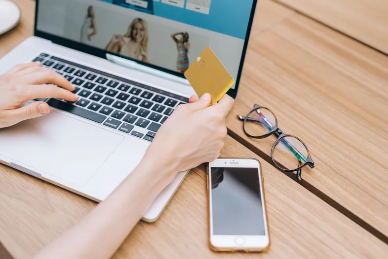 Shopper completing an online purchase on a laptop, the final action a landing page template needs to drive